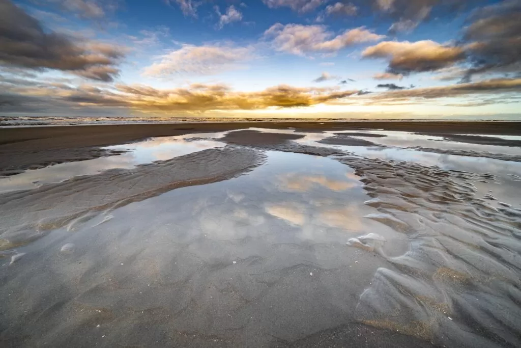 high-angle-shot-water-puddles-shore-with-blue-sky.jpg 16-01-40-976